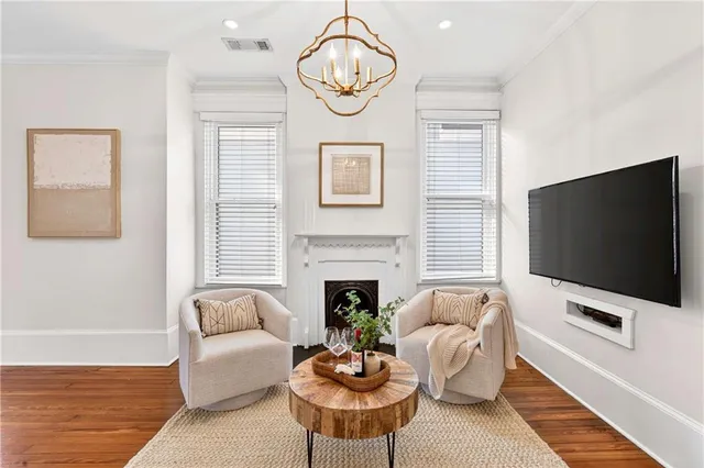 a living room with furniture a fireplace and a chandelier