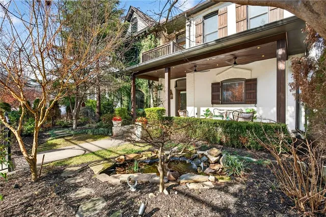 a view of a patio with table and chairs potted plants and floor to ceiling window
