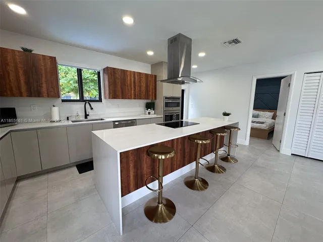 a kitchen with stainless steel appliances kitchen island granite countertop a sink stove and cabinets