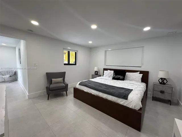 a spacious bedroom with a bed and a chandelier