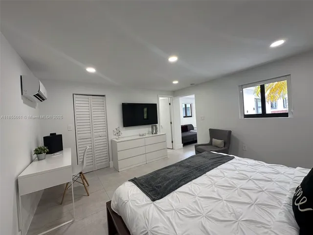 a bedroom with a bed and a flat screen tv