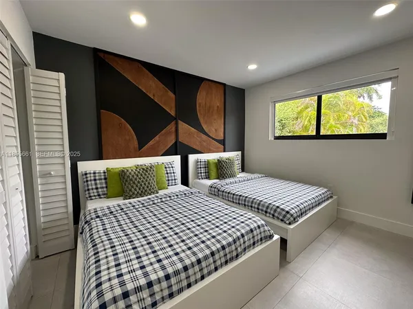 a bedroom with two beds and a window