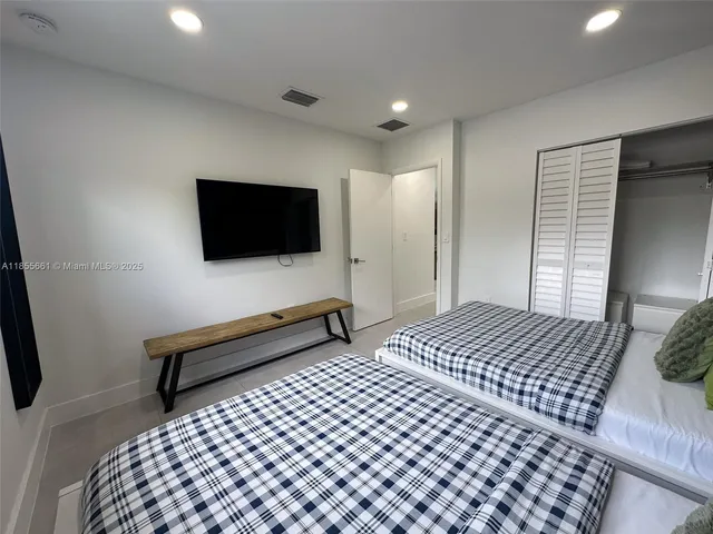a bedroom with a bed and a flat screen tv