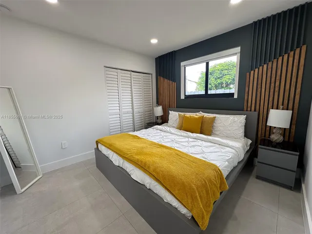 a bedroom with a large bed and a window