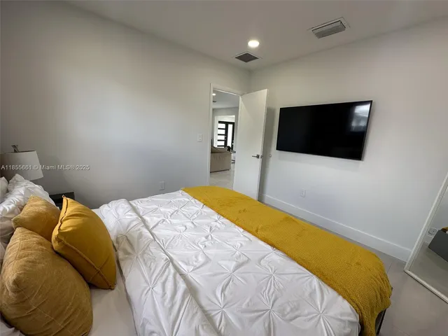 a bedroom with a bed and a flat screen tv