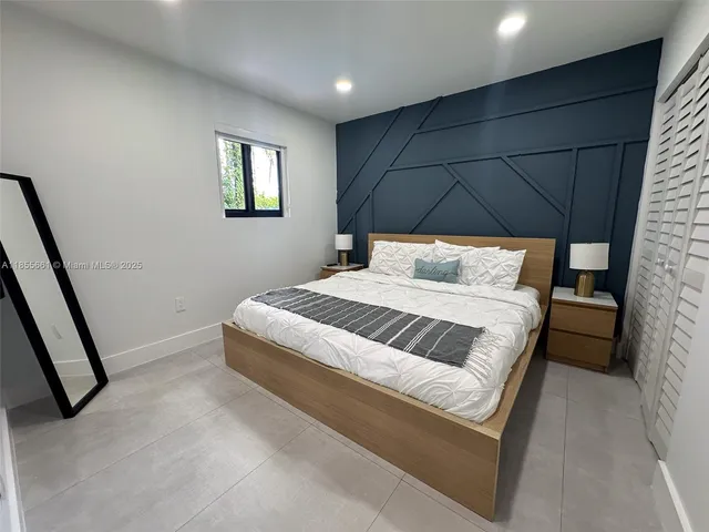 a bedroom with a bed and a mirror