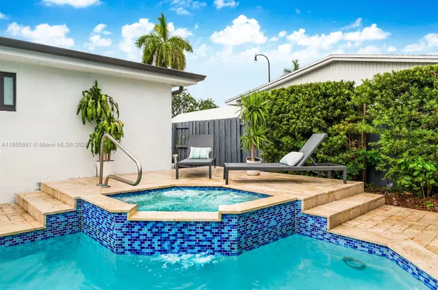 a view of a house with swimming pool and sitting area