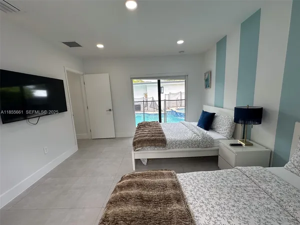 a bedroom with a large bed and a flat screen tv