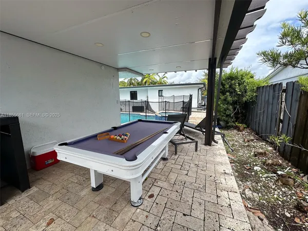 a room with pool table and windows