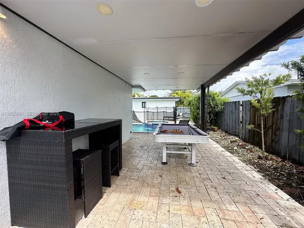 a view of a patio with table and chairs potted plants with wooden fence