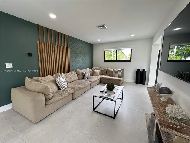 a living room with furniture a rug and a flat screen tv
