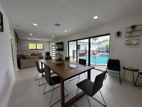 a view of a dining room with furniture large windows and wooden floor