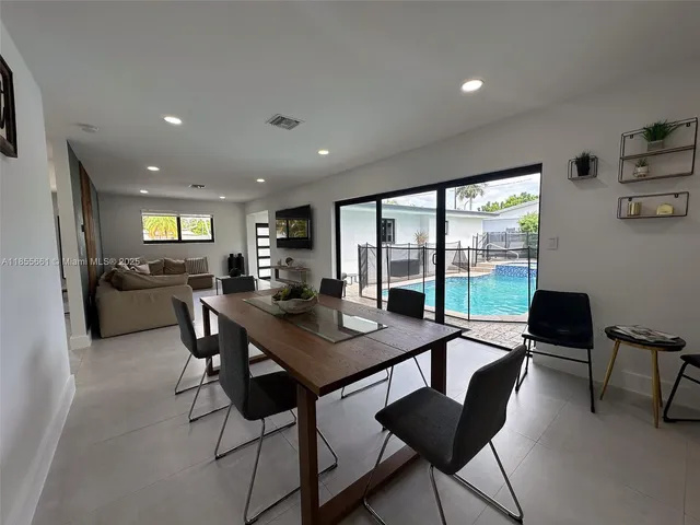 a view of a dining room with furniture large windows and wooden floor
