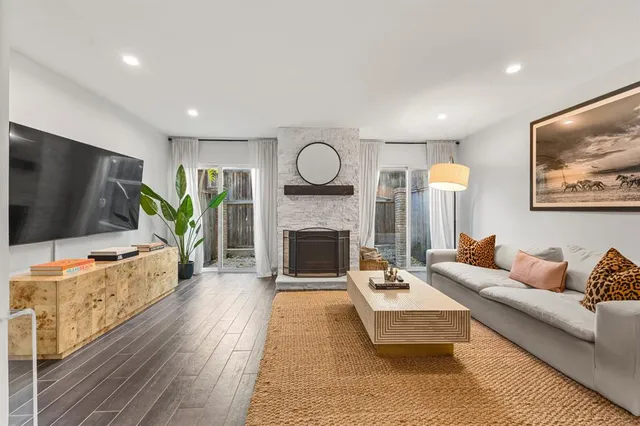 a living room with furniture a flat screen tv and a fireplace