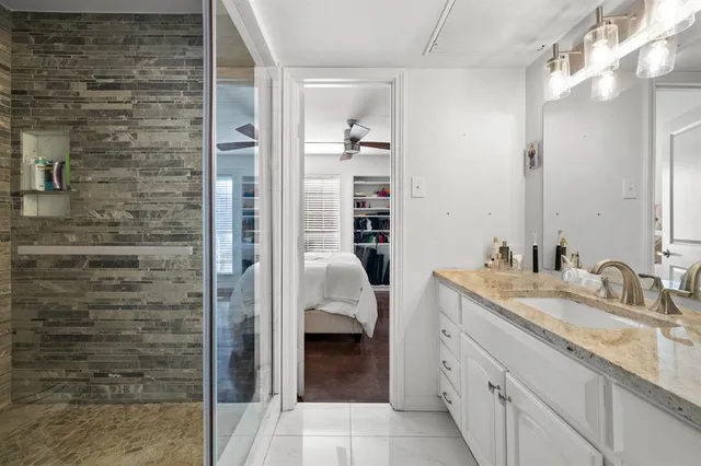 a en suite bathroom with a granite countertop sink and a mirror