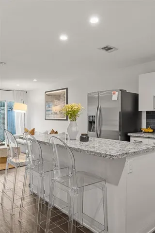 a large kitchen with granite countertop a sink and a refrigerator