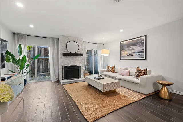 a living room with furniture a fireplace and a potted plant