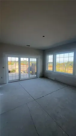 a view of an empty room with a window and fireplace