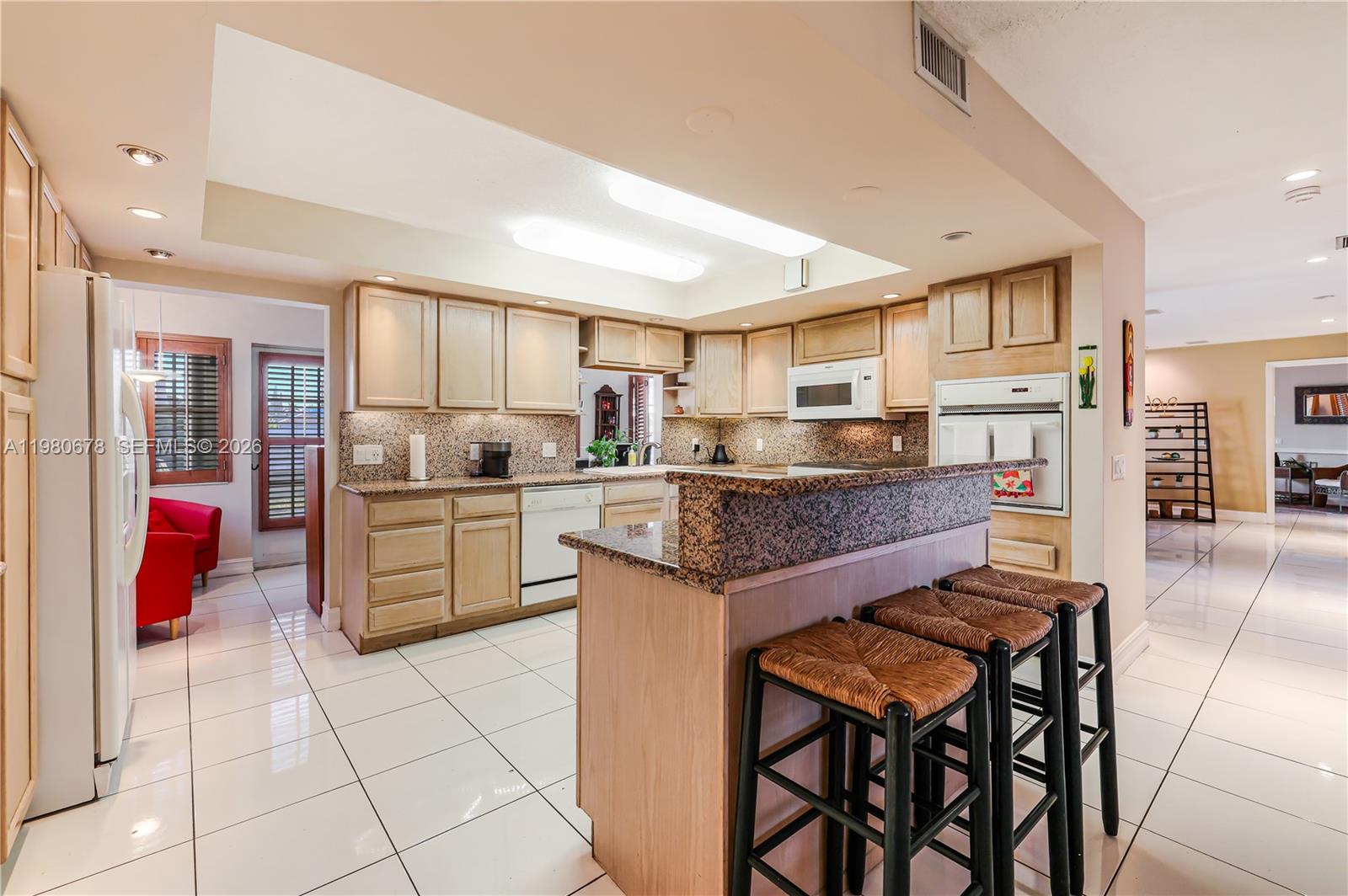 14952 Southwest 149th Street Miami, FL 33196 - Photo 20 of 64 a kitchen with kitchen island granite countertop wooden cabinets and counter space