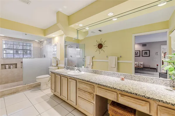 a spacious bathroom with a granite countertop sink a toilet and shower