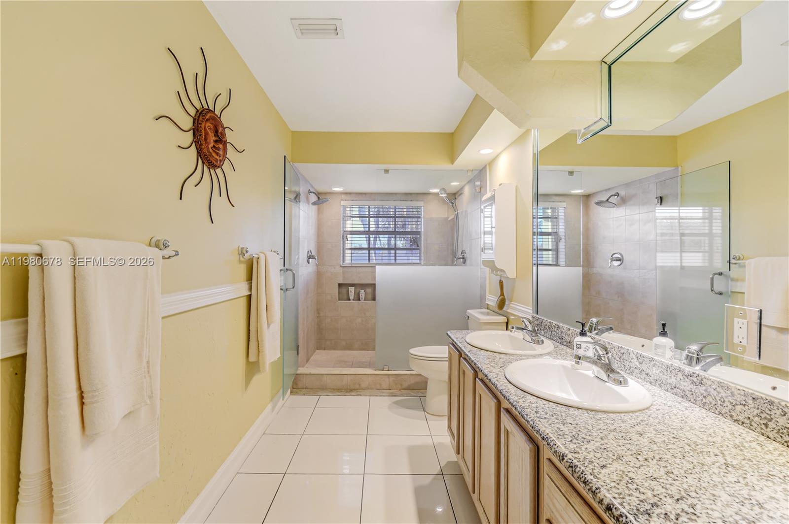 14952 Southwest 149th Street Miami, FL 33196 - Photo 31 of 64 a bathroom with a granite countertop sink a mirror a bathtub and a shower