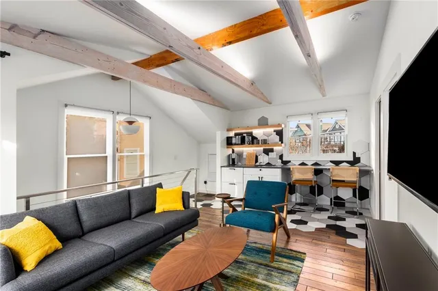 a living room with furniture a flat screen tv and a floor to ceiling window