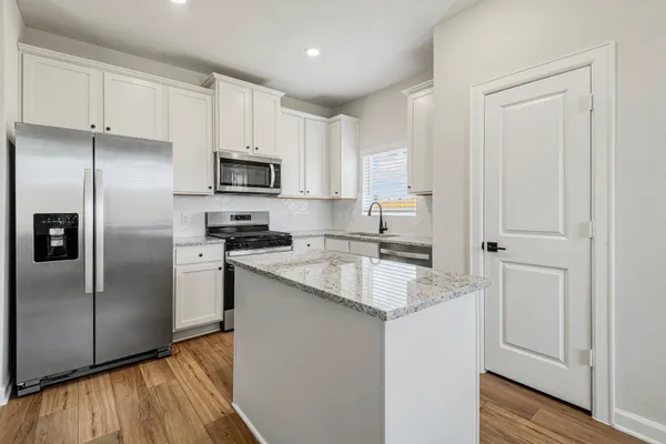 a kitchen with stainless steel appliances granite countertop a refrigerator sink and microwave