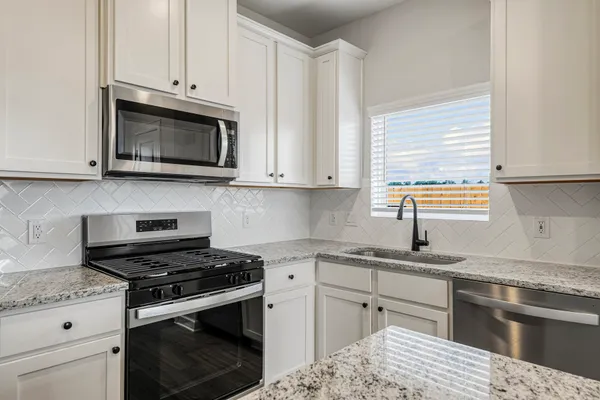 a kitchen with cabinets stainless steel appliances and a sink