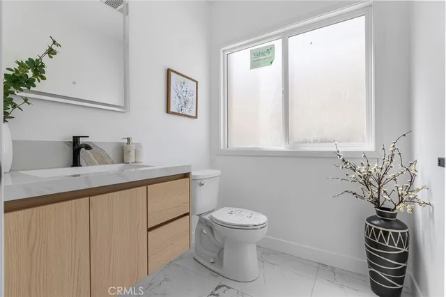 a bathroom with a toilet a sink and a window