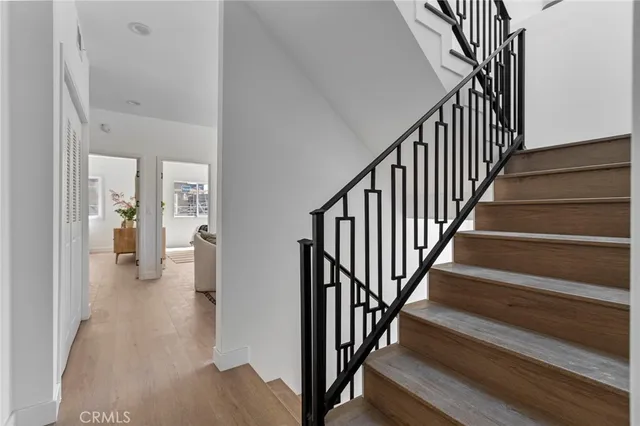 a view of a hallway with wooden floor and staircase