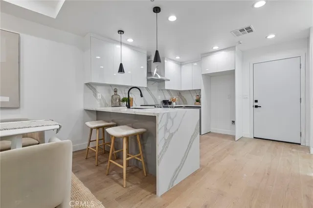 a kitchen with kitchen island stainless steel appliances a sink and cabinets