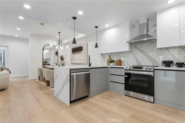 a kitchen with stainless steel appliances kitchen island granite countertop a stove and a sink