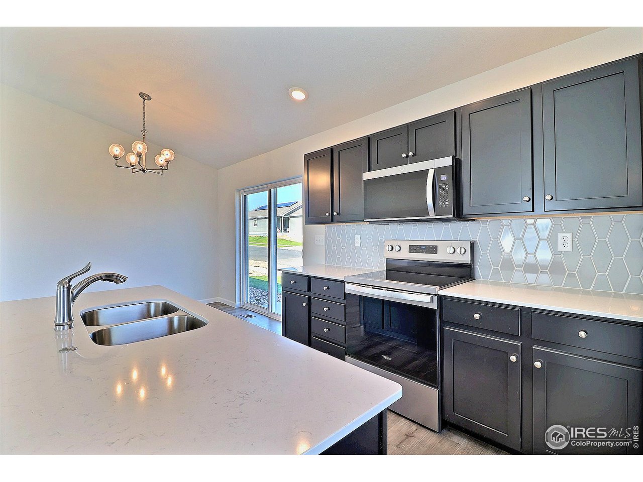 4301 Rockcress Road Evans, CO 80620 - Photo 16 of 26 a kitchen with kitchen island a sink stainless steel appliances and cabinets