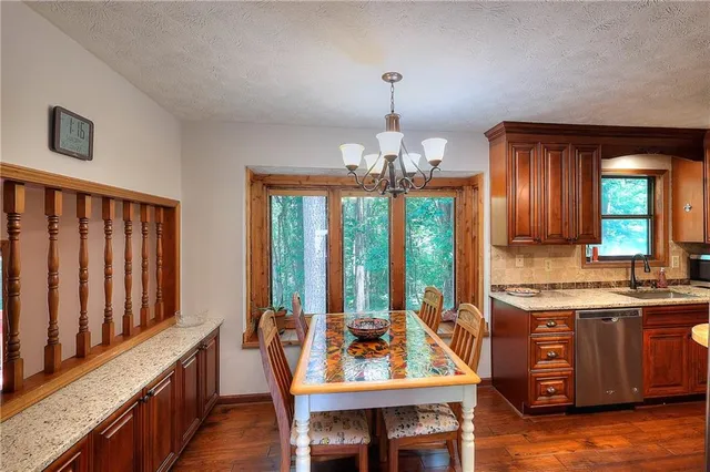 a view of a kitchen with granite countertop a sink and a refrigerator