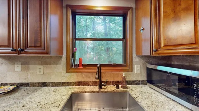 a kitchen with granite countertop a sink and a stove