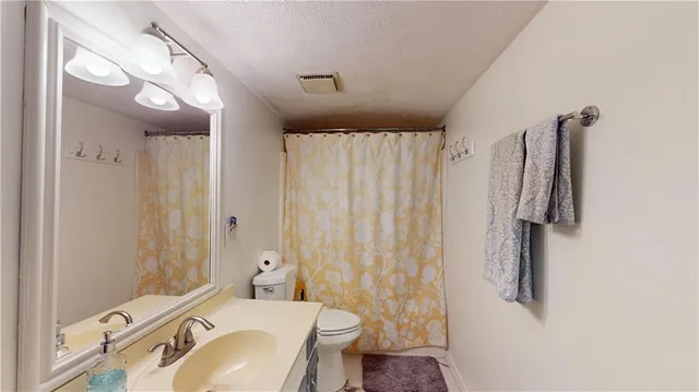 a bathroom with a sink vanity mirror and toilet