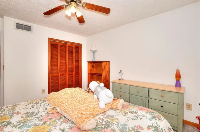 a bedroom with a bed and a large window with couch