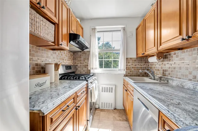 a kitchen with stainless steel appliances granite countertop a sink stove and cabinets