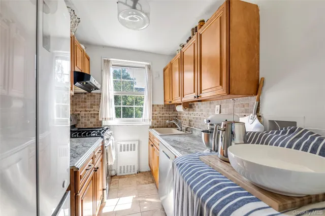 a kitchen with sink refrigerator and window