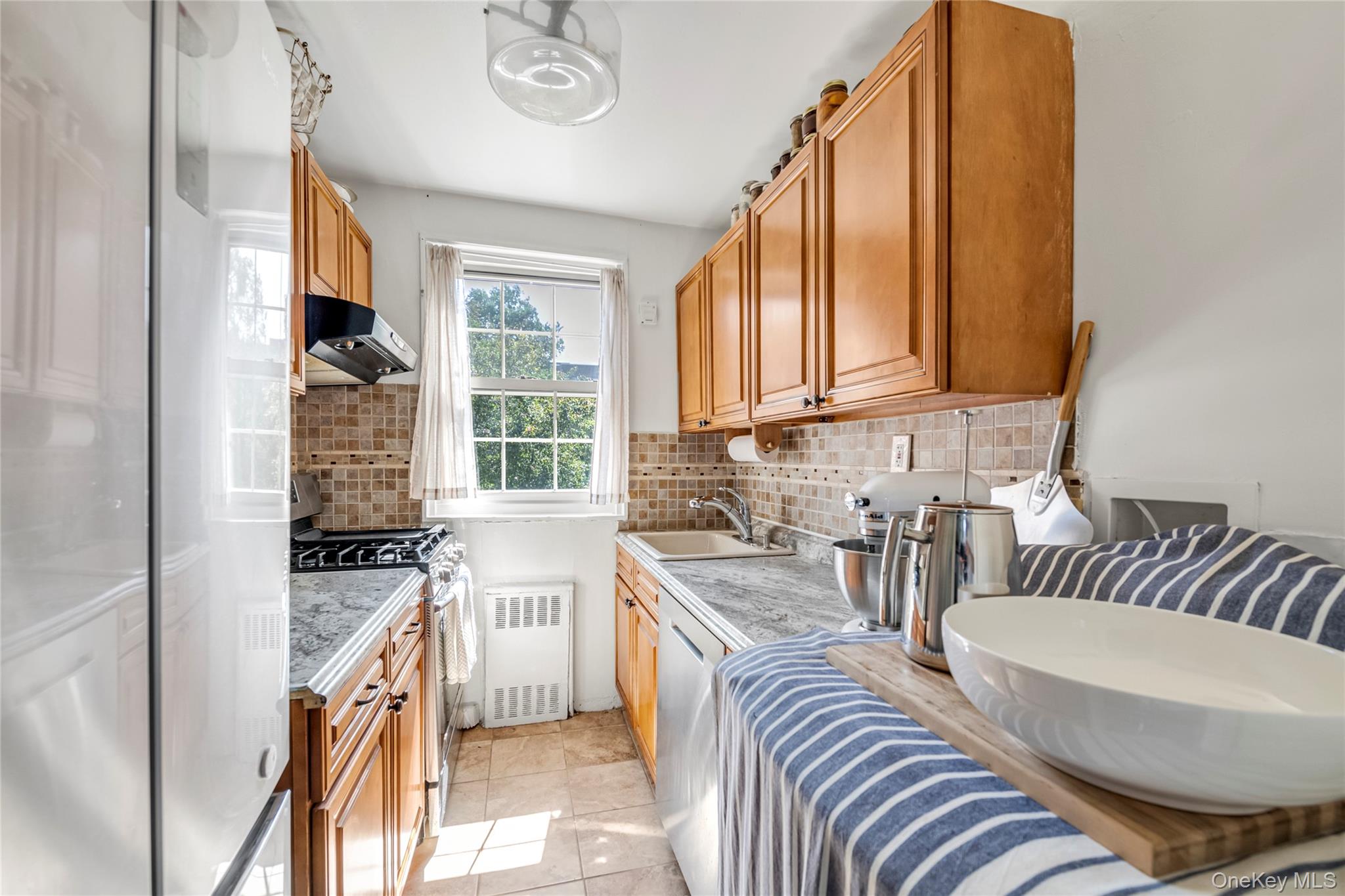 211-11 73rd Avenue, Unit B Queens, NY 11364 - Photo 6 of 11 a kitchen with sink refrigerator and window