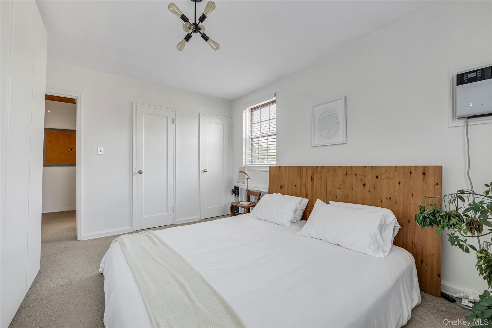 211-11 73rd Avenue, Unit B Queens, NY 11364 - Photo 8 of 11 a bedroom with a bed and a potted plant