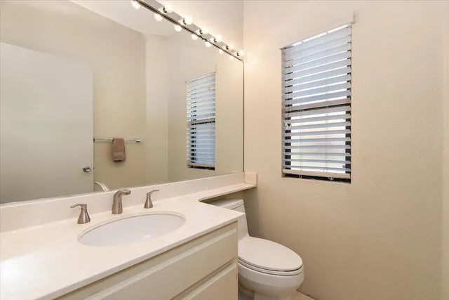 a bathroom with a sink a toilet and a mirror