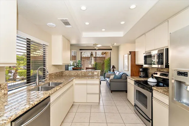 a kitchen with stainless steel appliances granite countertop a sink and cabinets