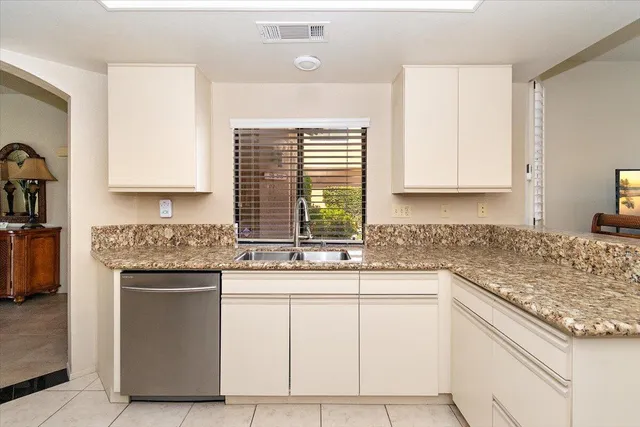 a kitchen with granite countertop white cabinets and white appliances