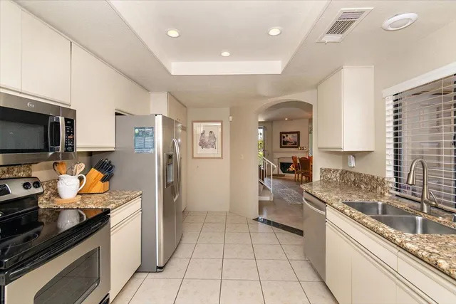 a kitchen with stainless steel appliances granite countertop a sink and a stove