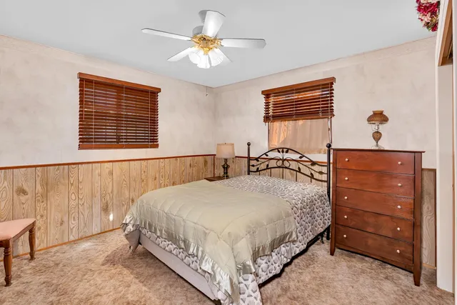 a bedroom with a bed and a dresser next to a window