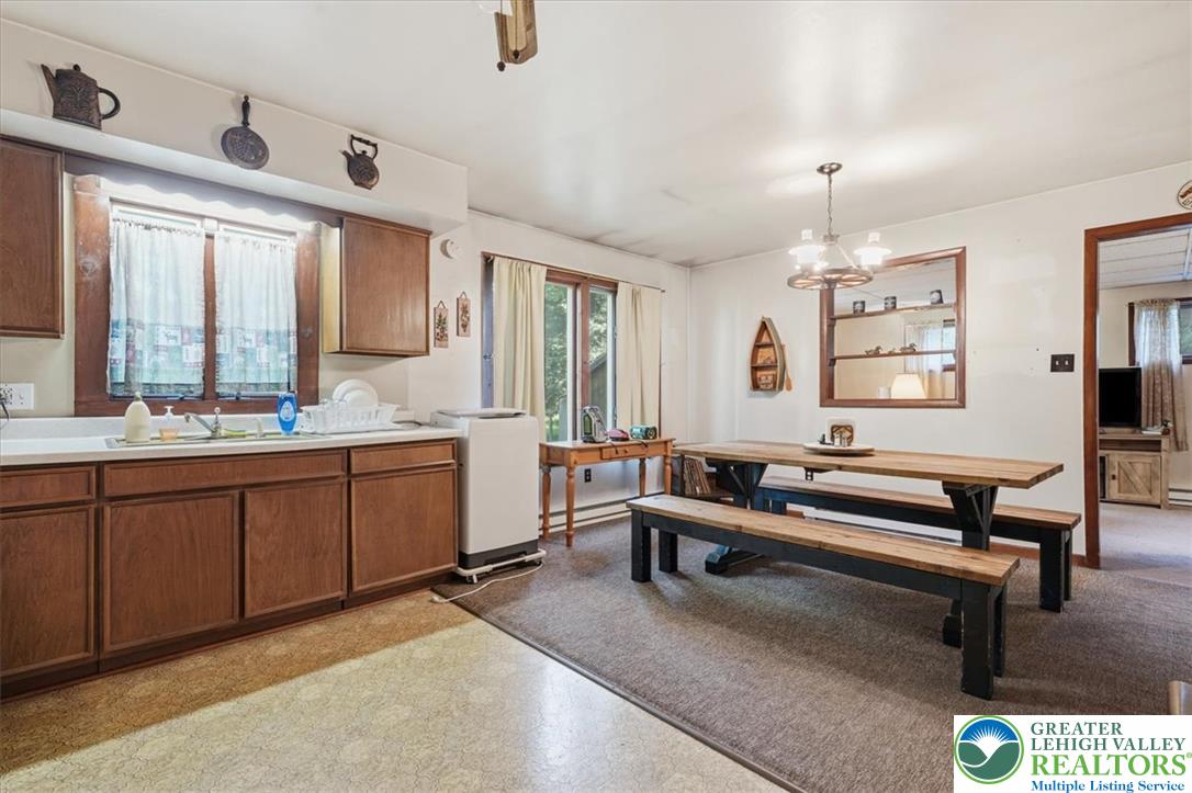 143 Logger Road Canadensis, PA 18325 - Photo 6 of 32 A well-lit kitchen with natural light, a comfortable dining area, and warm wood cabinetry.