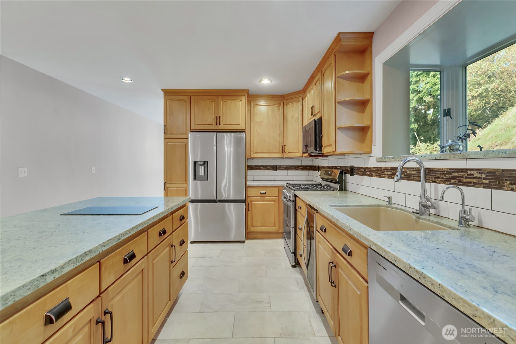 1622 Southwest 140th Street Burien, WA 98166 - Photo 6 of 38 a kitchen with stainless steel appliances granite countertop a sink a refrigerator and a granite counter tops with a large window