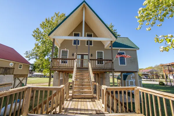 a view of a brick house with large windows and a small yard