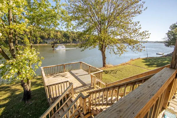 a view of a balcony with lake view and wooden fence